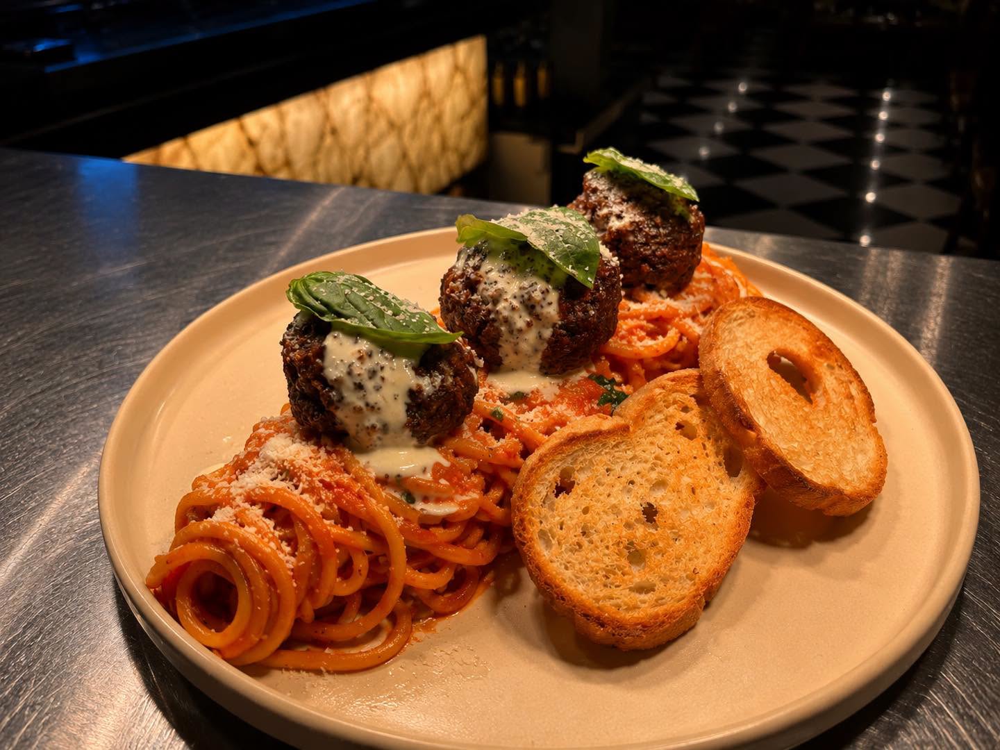 Spaghetti topped with meatballs and basil