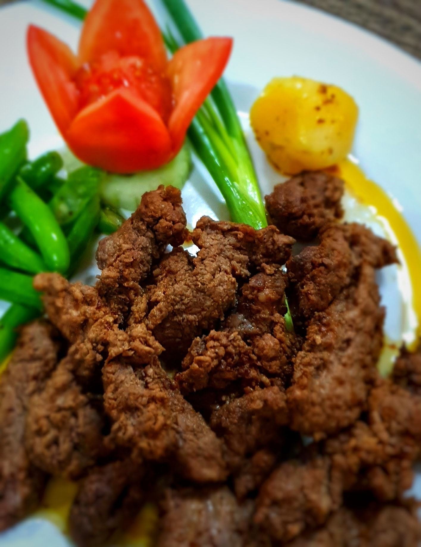 Fried beef bites served with vegetables and potato