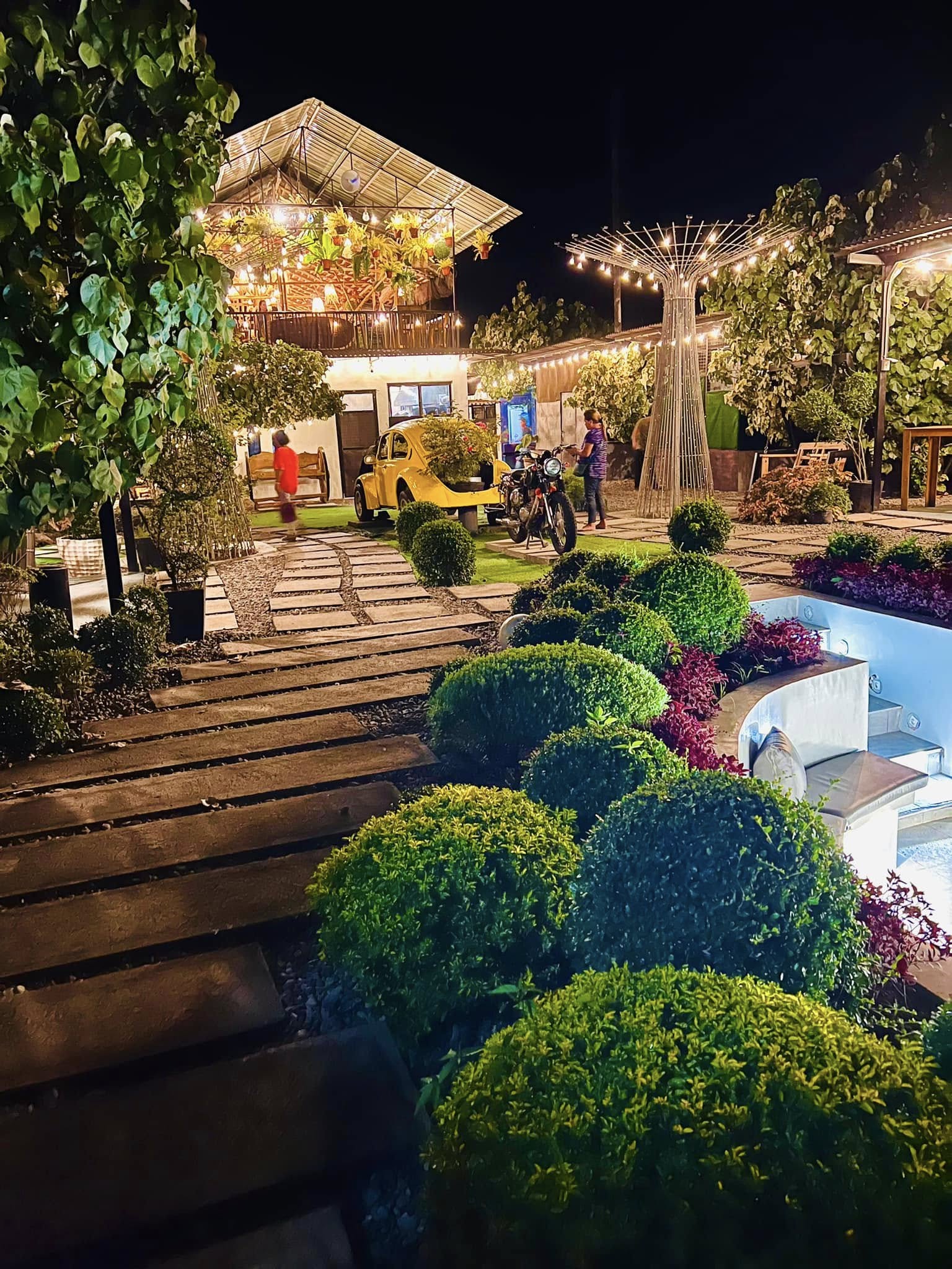 Garden paths and circular seating illuminated at night at D’ Garden at Calatao