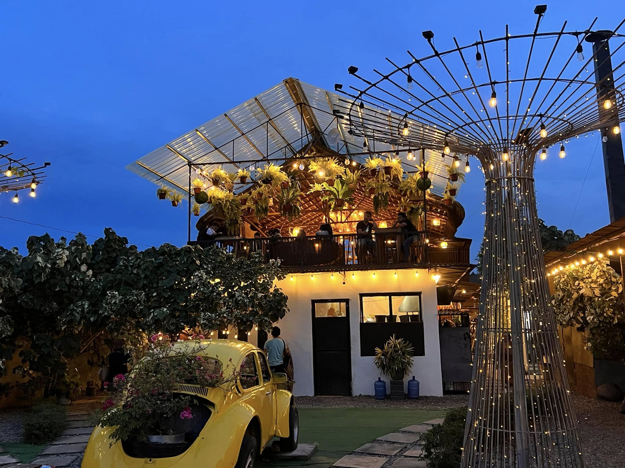 Evening lights, bamboo pavilion, and yellow car display at D’ Garden at Calatao