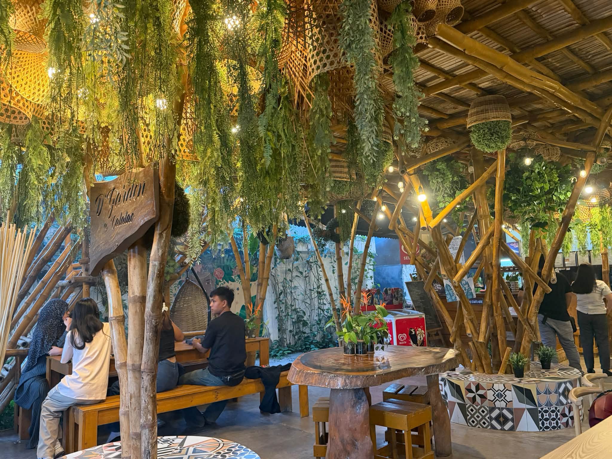 Wooden tables and woven seats under bamboo beams at D’ Garden at Calatao