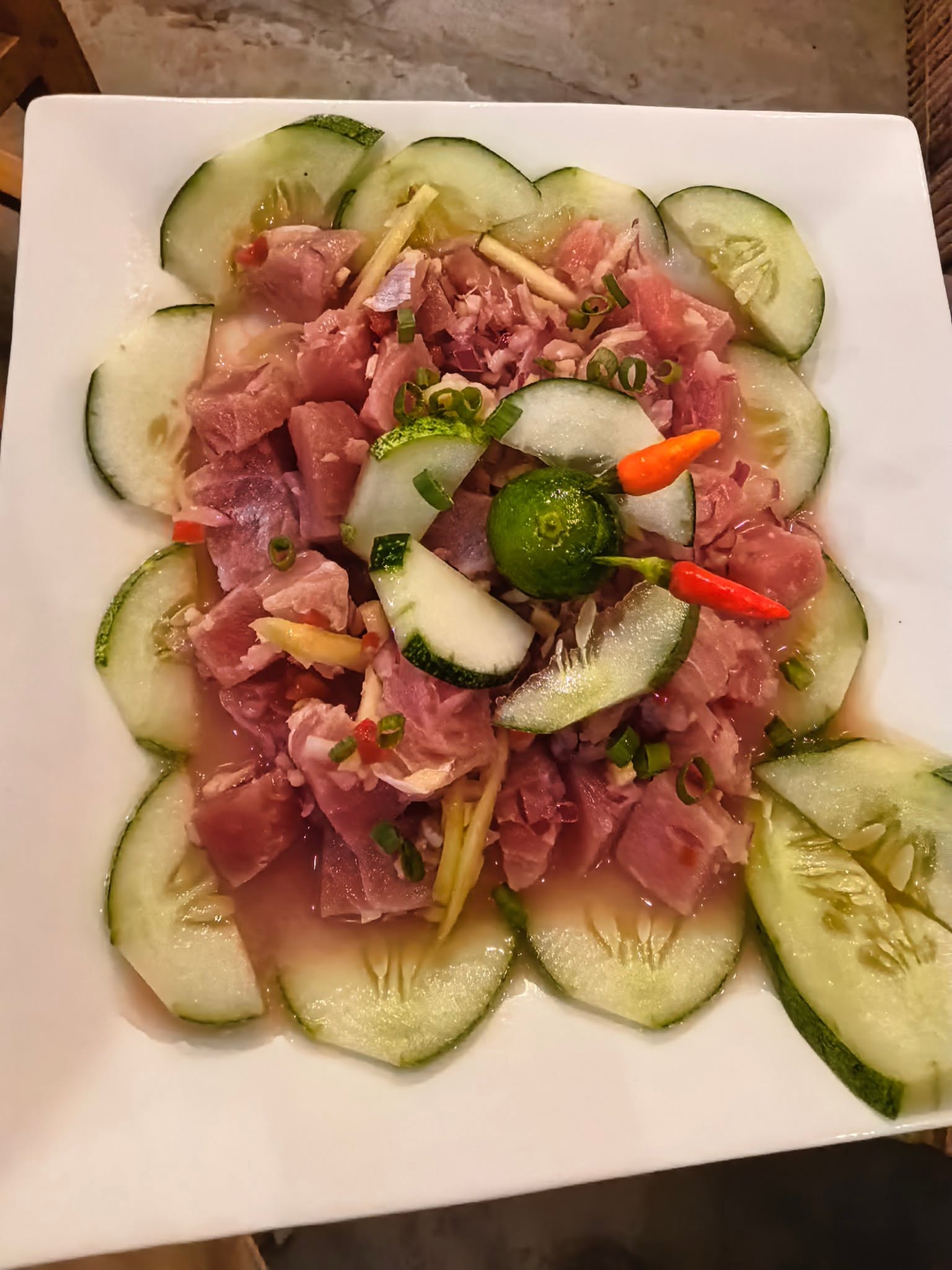 Fish dish with sliced cucumber, citrus, and chillies photographed at D’ Garden at Calatao