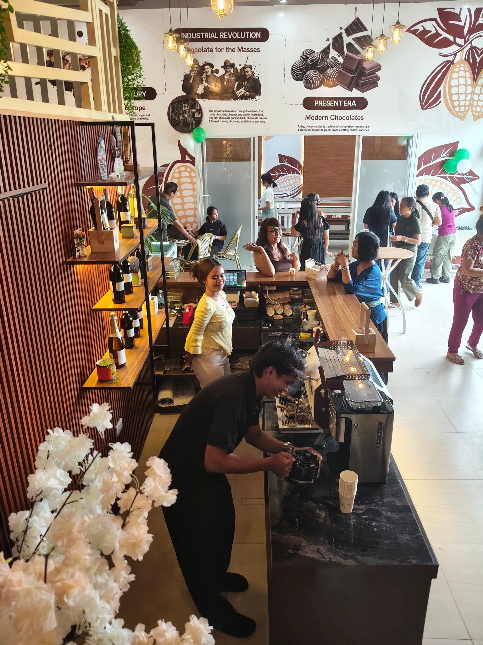 Busy Don Ricardo café counter beneath a chocolate history wall