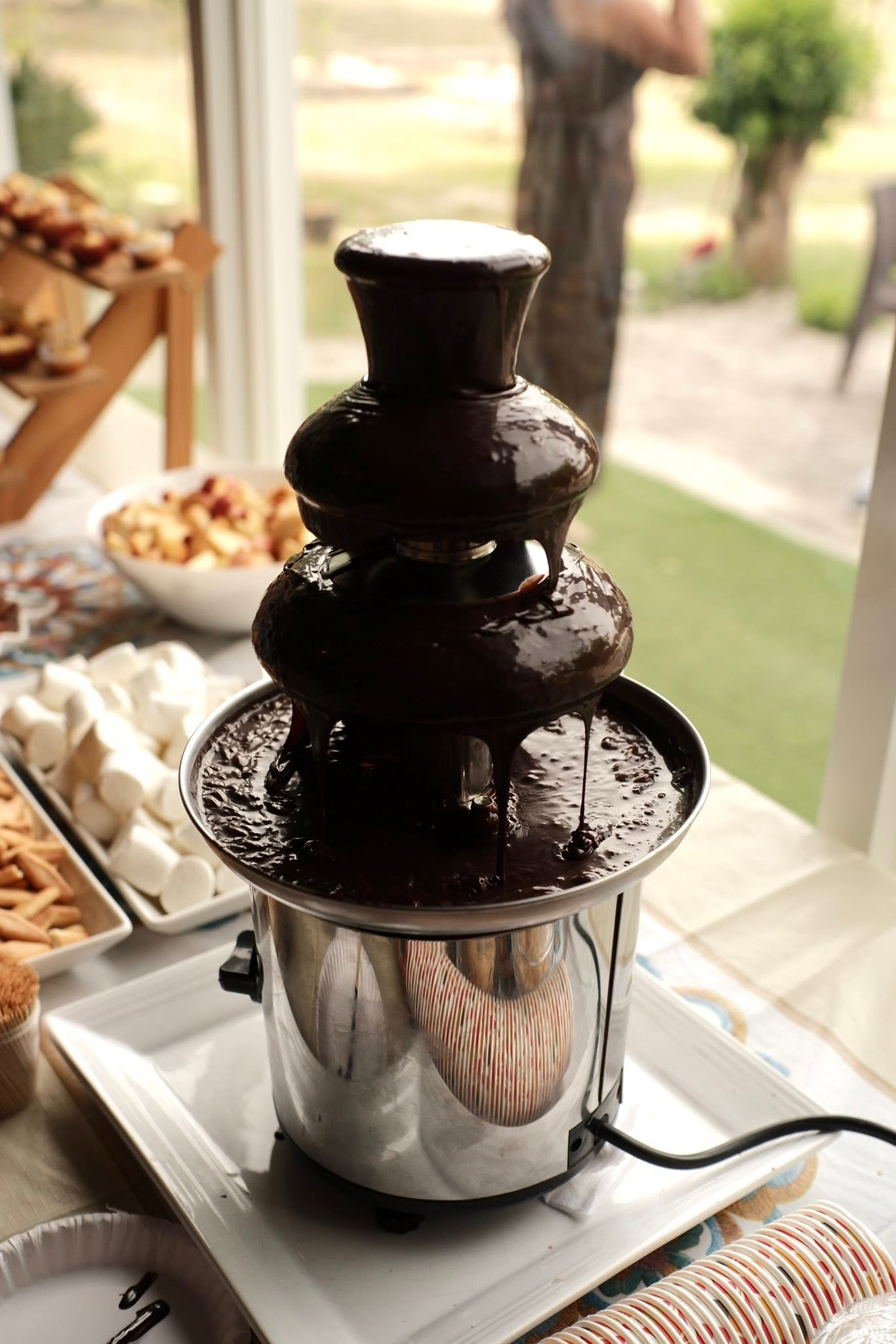 Flowing chocolate fountain prepared for dipping treats