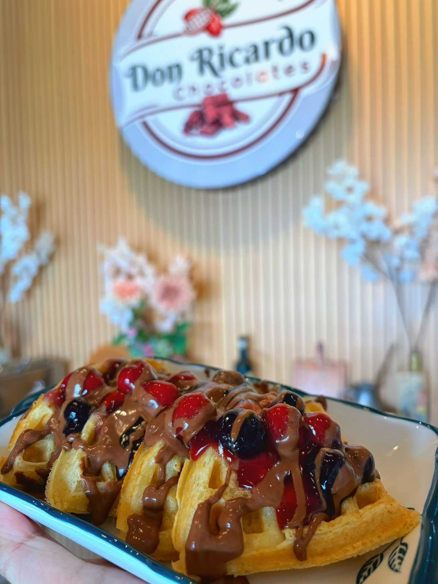 Waffles topped with berries and chocolate sauce