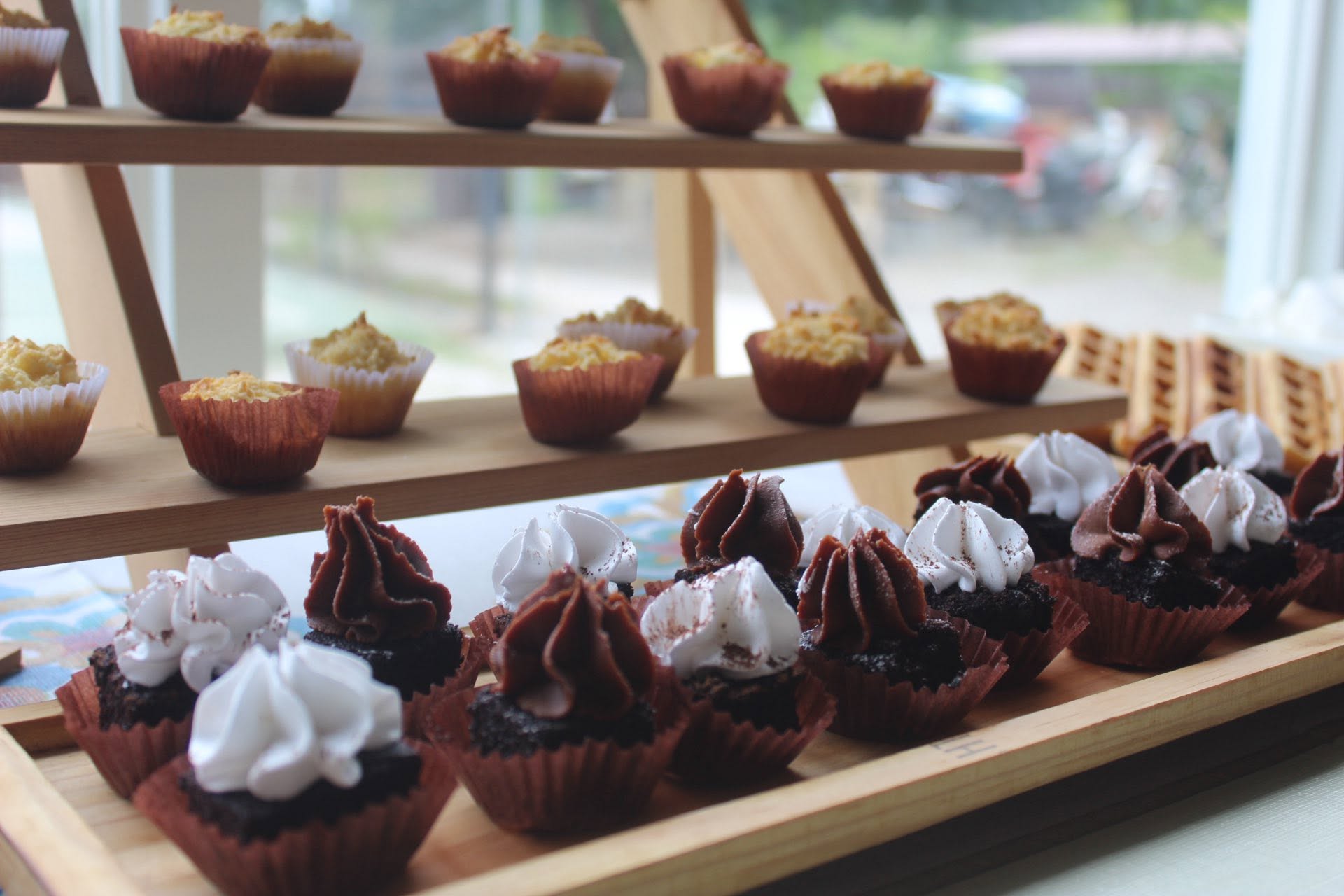 Chocolate cupcakes and pastries displayed on wooden stands