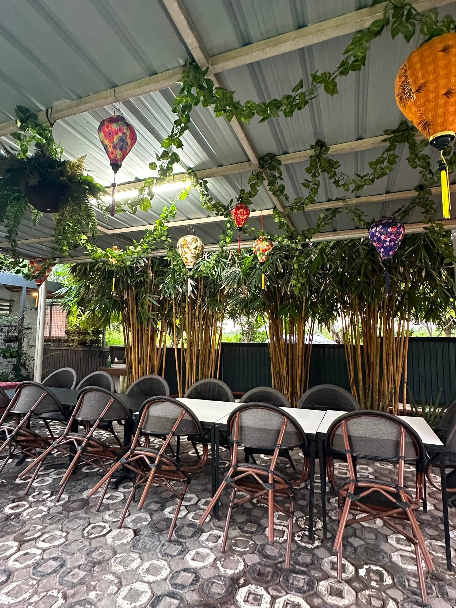 Covered alfresco dining area with plants and lanterns