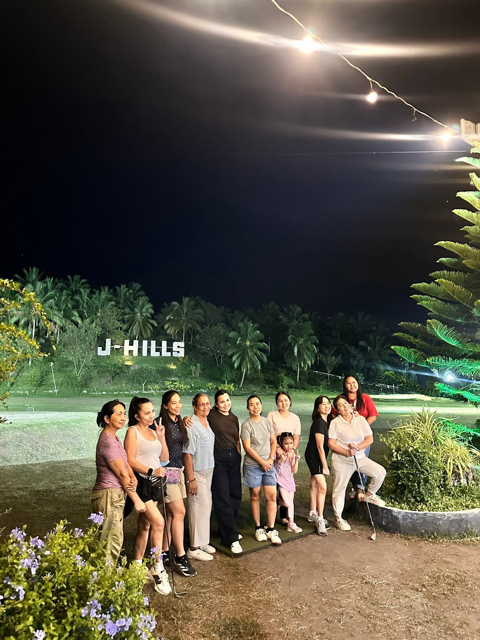 Group posing beside the lighted J-Hills driving range