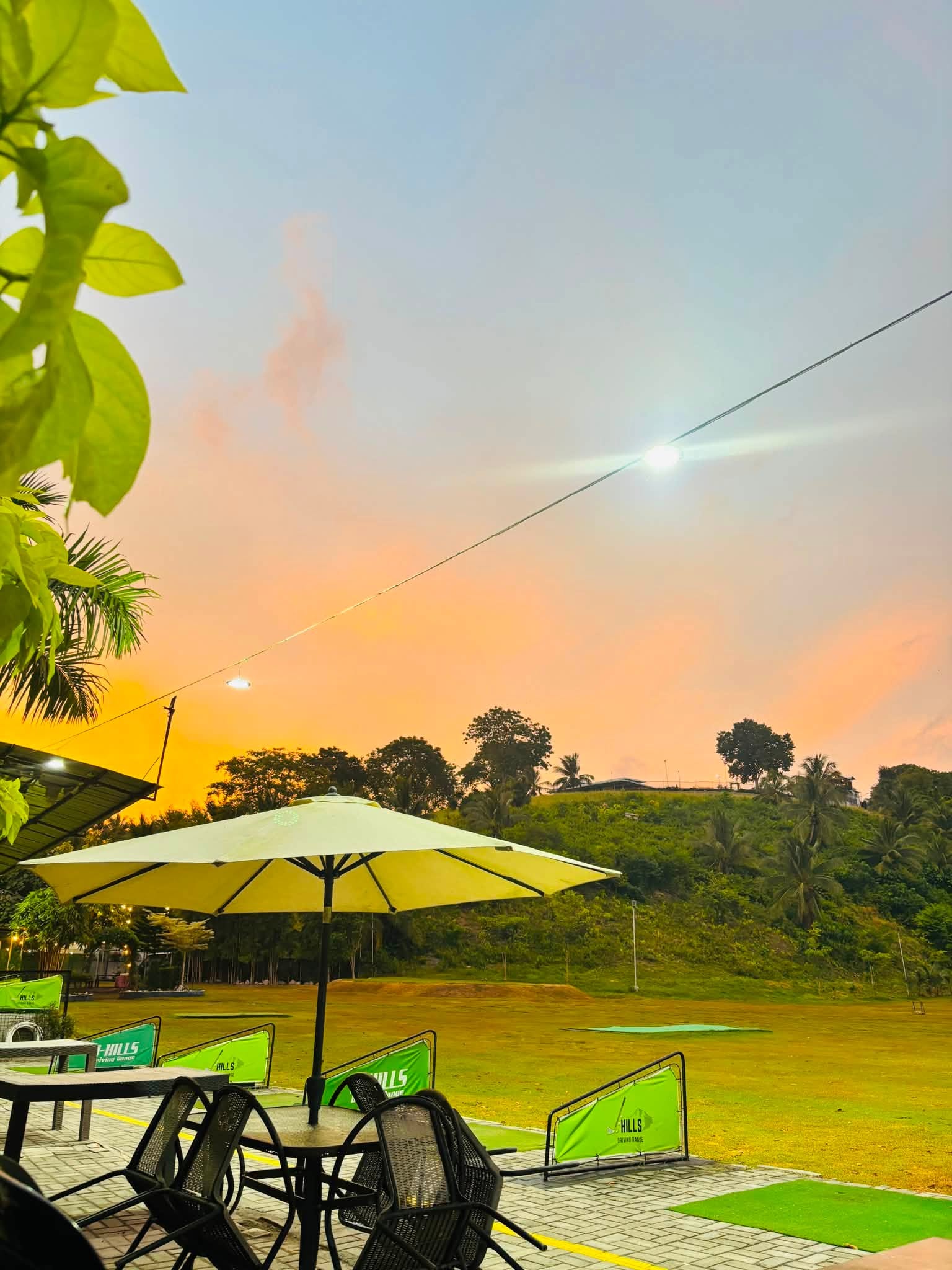 Sunset over the J-Hills driving range and outdoor tables