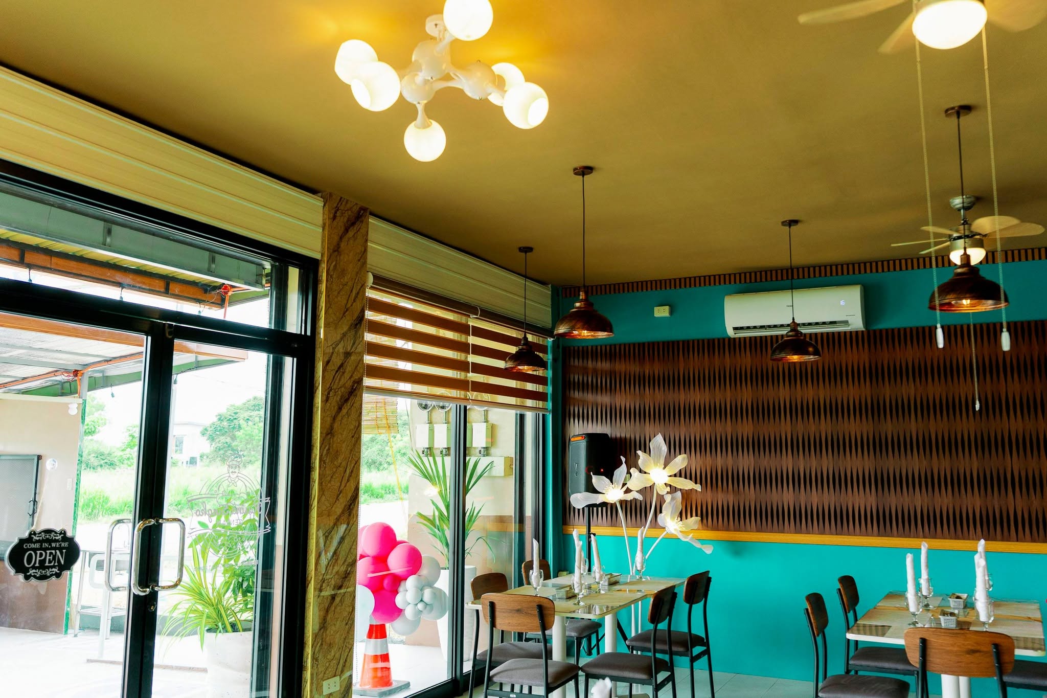 Indoor seating with teal walls and pendant lights