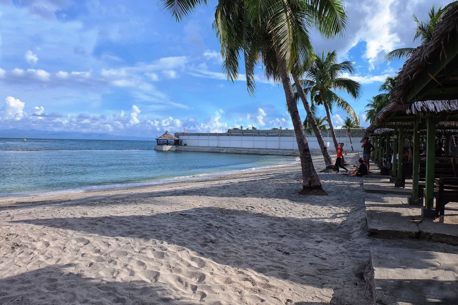 Palm-lined beach and seaside cottages at London Beach Resort