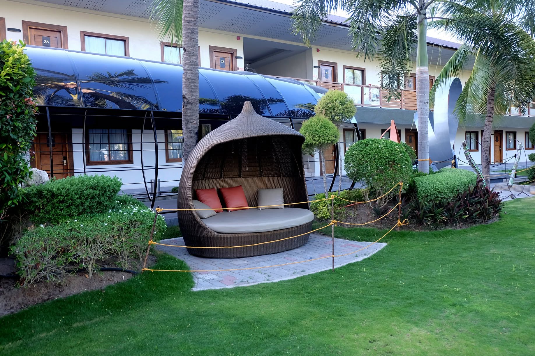 Covered garden daybed among palms at London Beach Resort