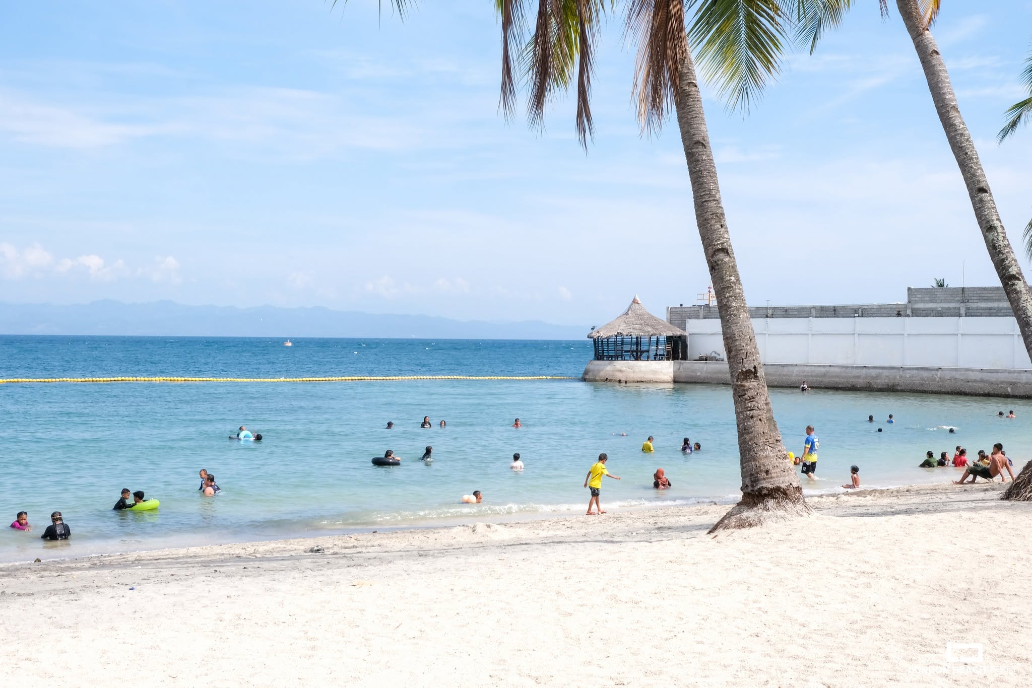 Guests swimming at the beachfront of London Beach Resort