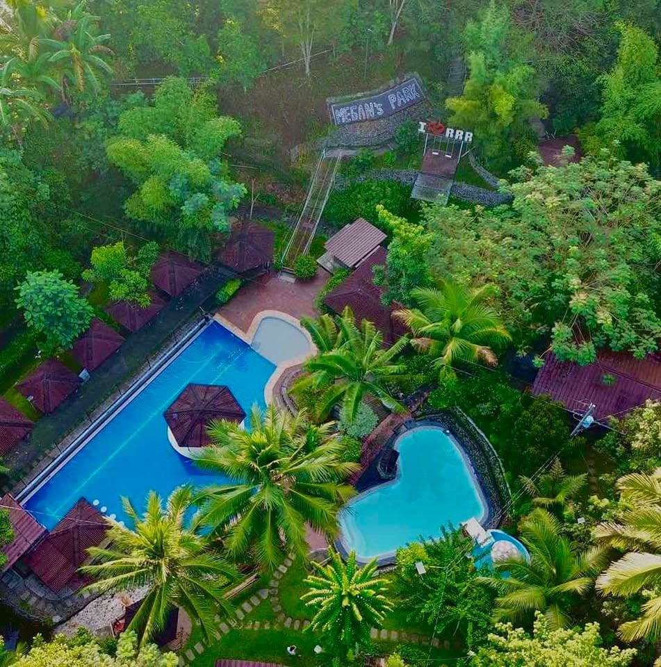 Aerial view of swimming pools, cottages, and greenery at River Ranch Resort