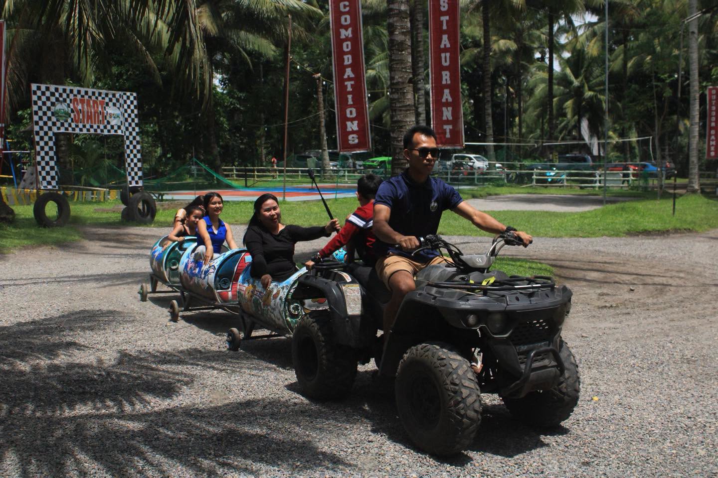 Visitors riding in train carriages pulled by an ATV