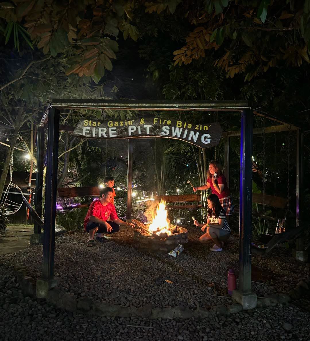 Visitors gathered around the Fire Pit Swing at night