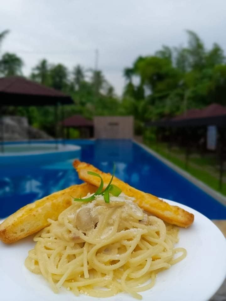 Creamy pasta and toasted bread beside the resort pool