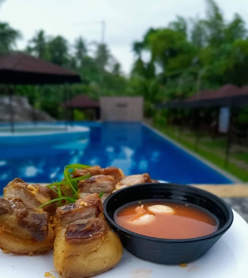 Pork pieces and dipping sauce served beside the pool