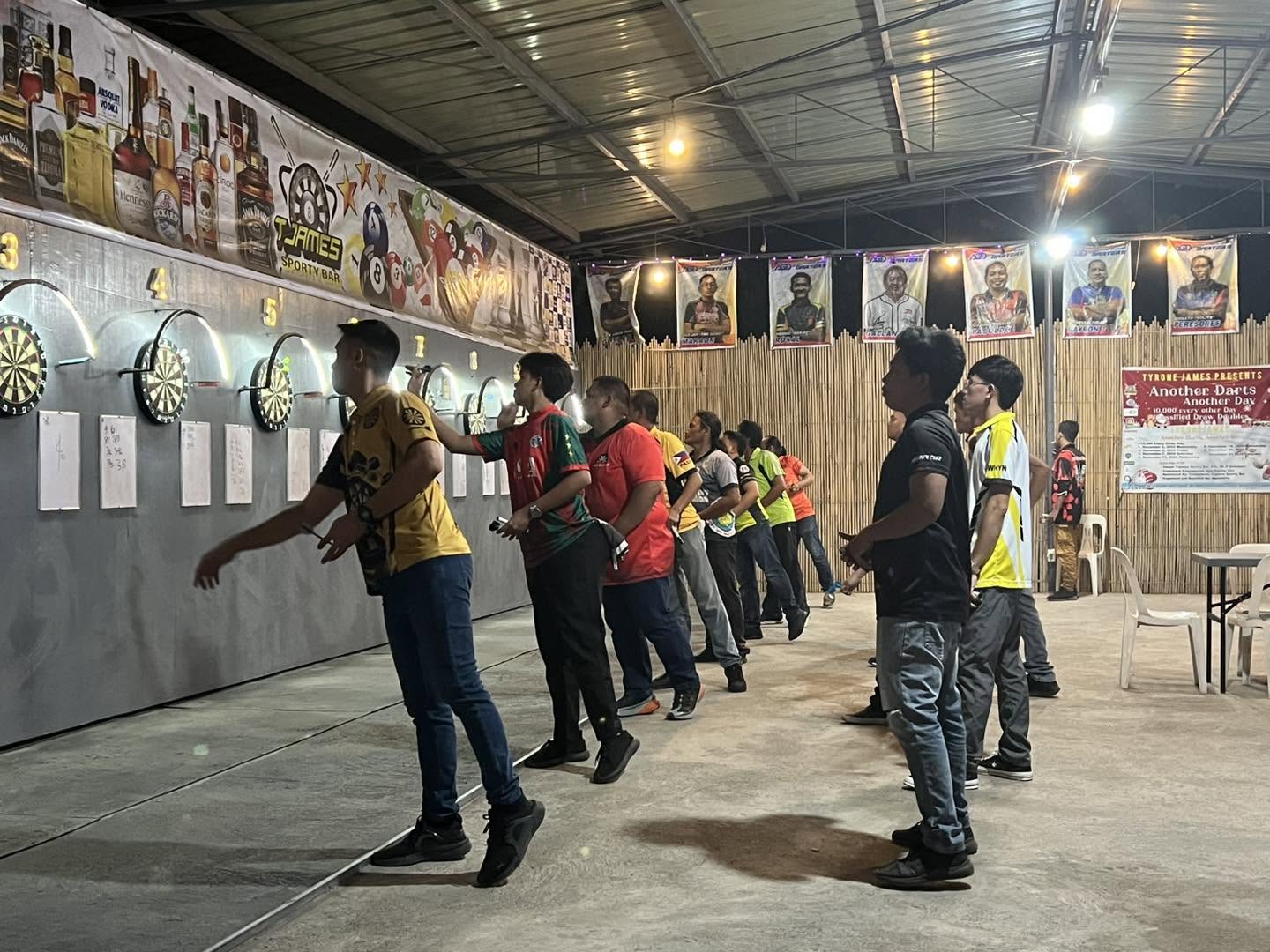 Players competing along the row of dartboards at T-James Sporty Bar