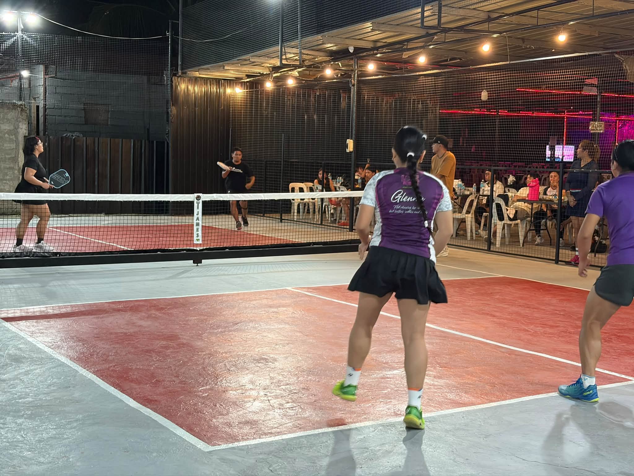 Pickleball doubles match beside the seating area at T-James Sporty Bar