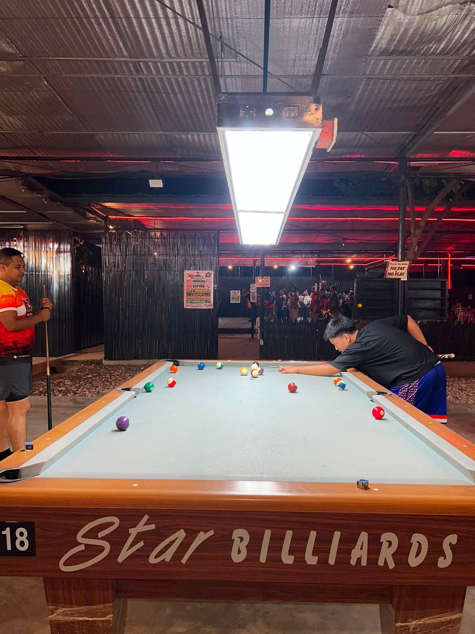 Billiards player lining up a shot at T-James Sporty Bar