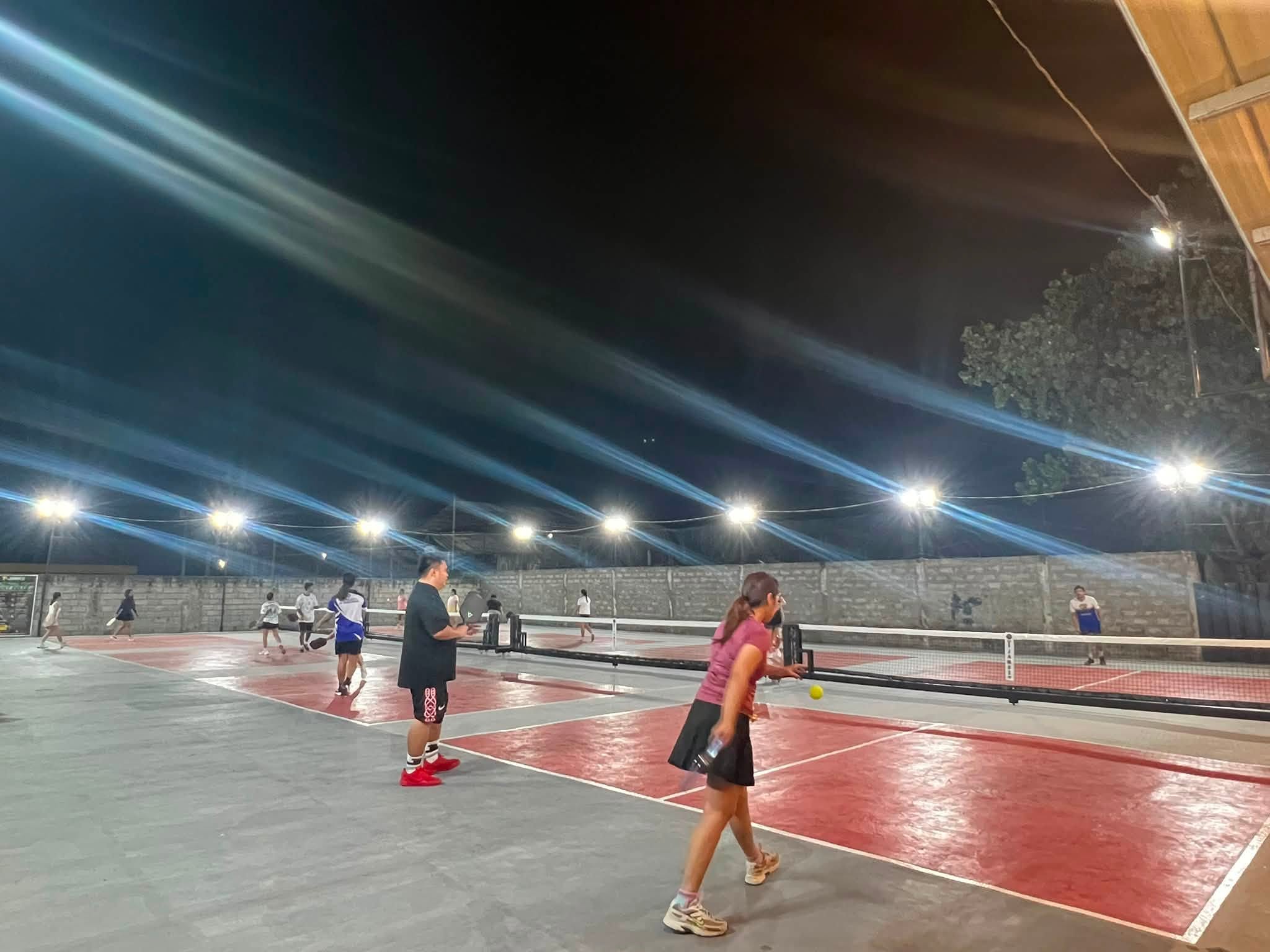 Pickleball doubles game under floodlights at T-James Sporty Bar