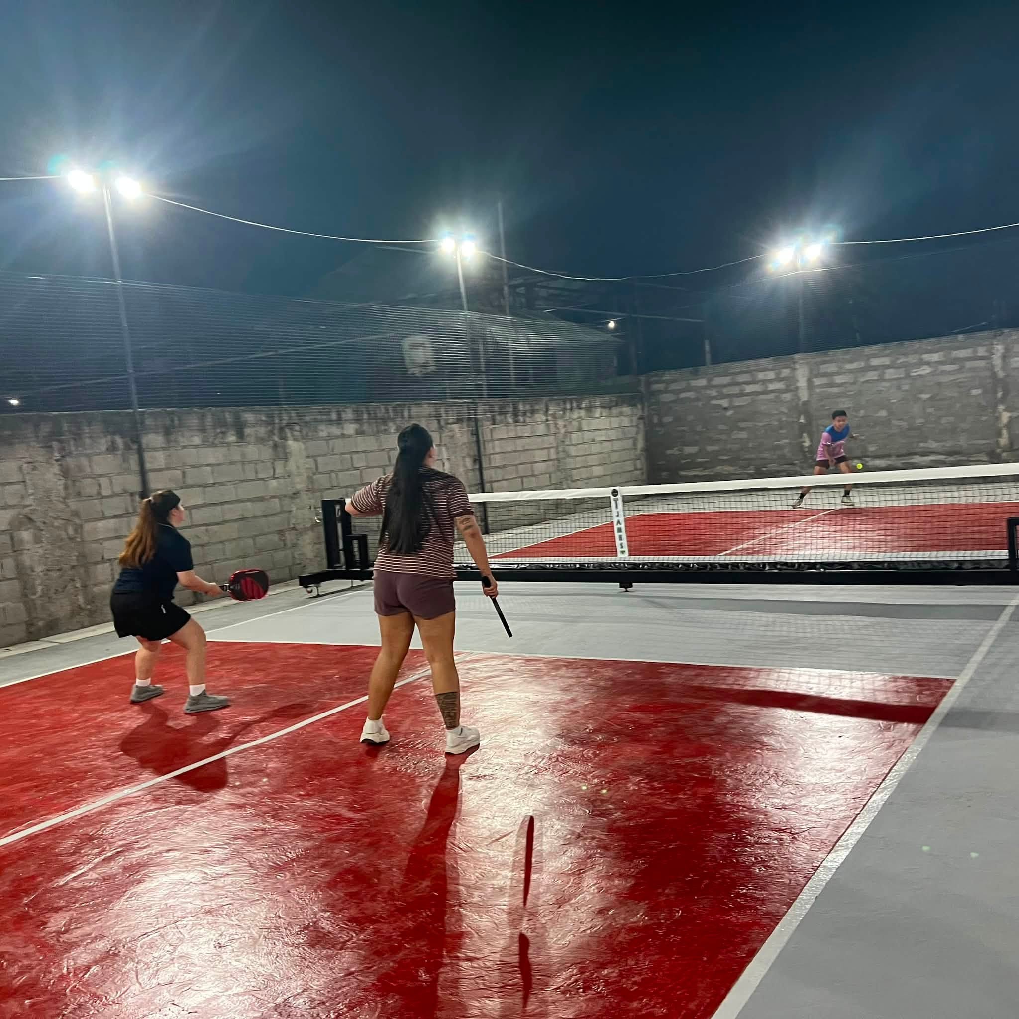 Pickleball players preparing for a return at T-James Sporty Bar