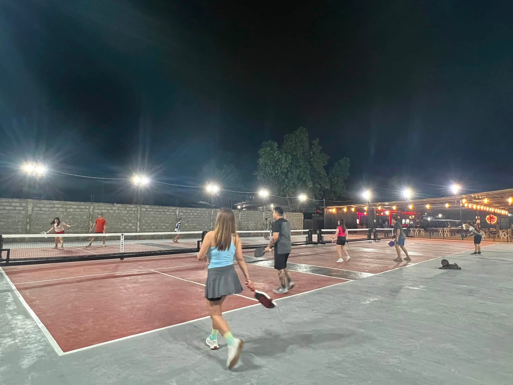 Pickleball action with the bar in the background at T-James Sporty Bar