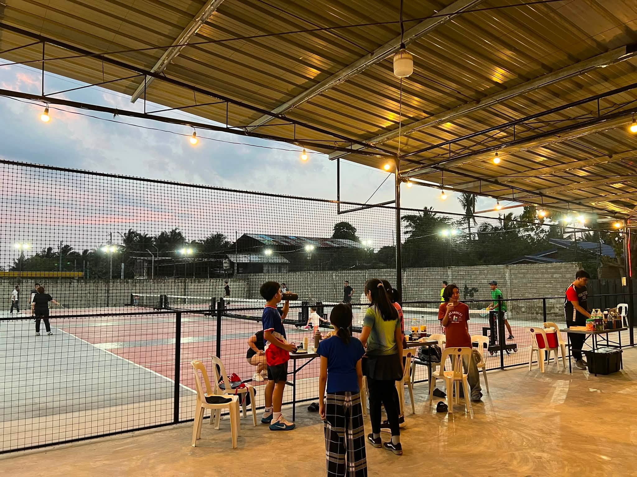 Courtside seating and pickleball at dusk at T-James Sporty Bar